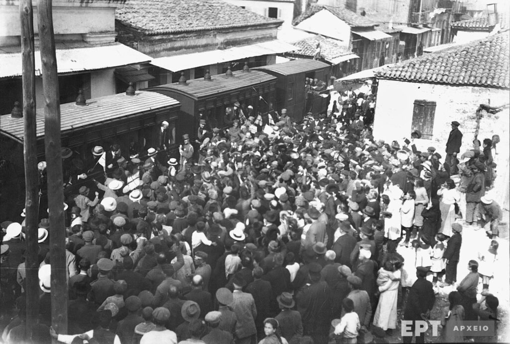 Άποψη της πόλης το 1924 με αμαξοστοιχία τρένου σε στάση, κατά τη διάρκεια του εορτασμού των 100 χρόνων από το θάνατο του Λ. Βύρωνα. Αρχείο Ε.Ρ.Τ. Α.Ε., Συλλογή Πέτρου Πουλίδη.